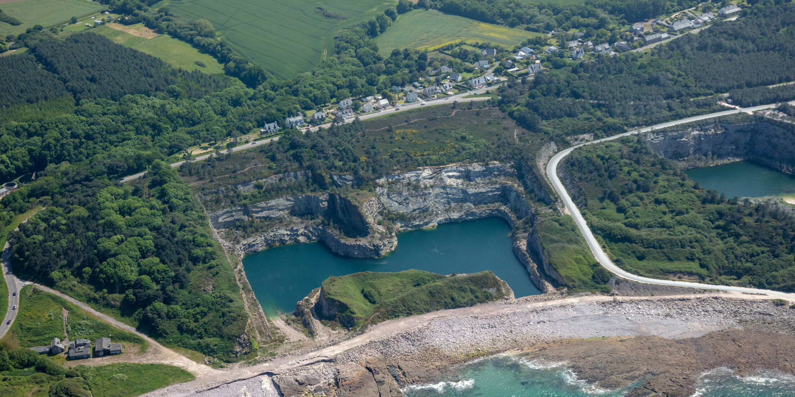 vue aérienne d'une ancienne carrière réaménagée en plan d'eau, en bord de mer